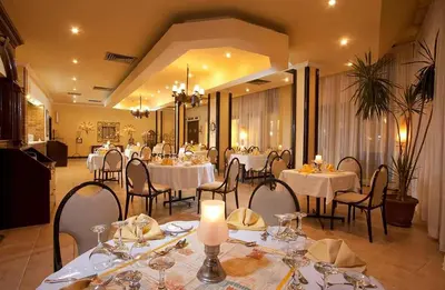a dining room with white tables and chairs at Regina Resort and Aqua Park Hurghada in Hurghada
