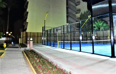 a fence next to a swimming pool at night at Regina Resort and Aqua Park Hurghada in Hurghada