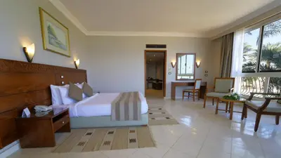 a bedroom with a large bed and a living room at Regina Resort and Aqua Park Hurghada in Hurghada
