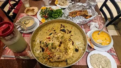 a table with a pot of soup and other food at Exoticky apartman in Hurghada
