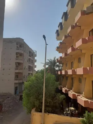 a row of tall buildings with trees and a street light at Exoticky apartman in Hurghada