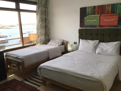 two beds in a room with a window at Villa Misk in Aswan