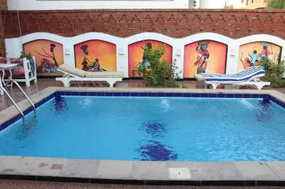 a swimming pool with a mural on the side of a building at Mama Africa Apts & Studios in Luxor