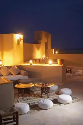 a patio with tables and chairs at night at Marina Lodge at Port Ghalib in Port Ghalib