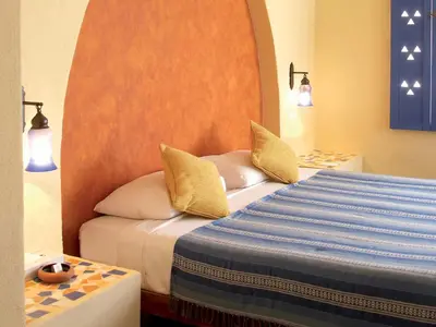 a bedroom with a bed with yellow pillows at Marina Lodge at Port Ghalib in Port Ghalib