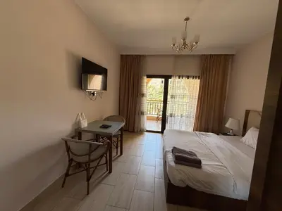 a bedroom with a bed and a desk and a table at AlDau Heights Apartments in Hurghada