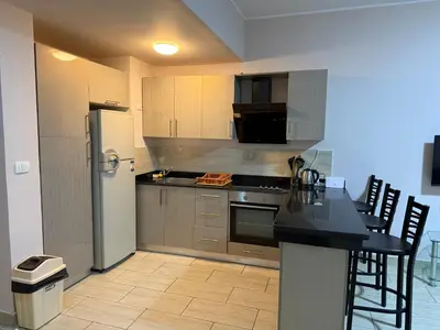 a kitchen with a refrigerator and a table with chairs at AlDau Heights Apartments in Hurghada