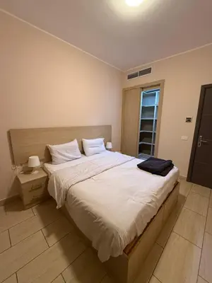 a bedroom with a large bed with white sheets at AlDau Heights Apartments in Hurghada