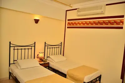 two beds in a room with an american flag on the wall at Dolphin Hotel Safaga in Safaga