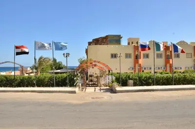 a large building with flags in front of it at Dolphin Hotel Safaga in Safaga