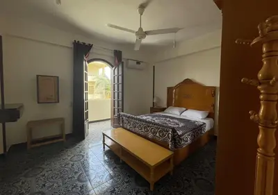 a bedroom with a bed and an open door at Gîte Hôtel Ramla Louxor in Luxor