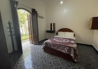 a bedroom with a bed and an open door at Gîte Hôtel Ramla Louxor in Luxor