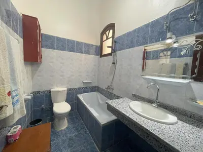a bathroom with a sink and a toilet and a tub at Gîte Hôtel Ramla Louxor in Luxor