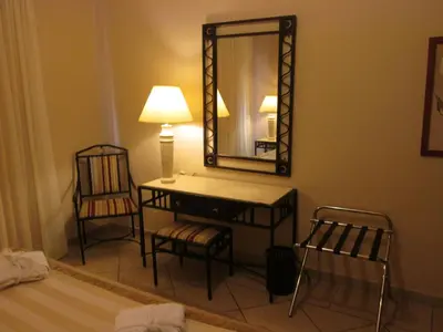 a bathroom with a vanity with a mirror and a chair at JAZ Neo Ivory in Hurghada