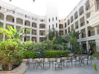 a courtyard with tables and chairs in front of a building at JAZ Neo Ivory in Hurghada