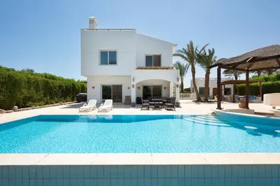a swimming pool in front of a villa at VESTA - El Gouna Residence in Hurghada