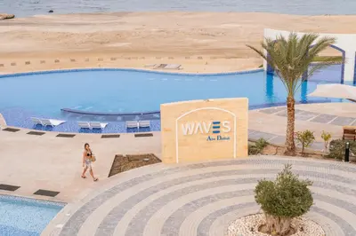 a woman walking by a swimming pool at a wes aval resort at Malikia Resort Abu Dabbab in Abu Dabab