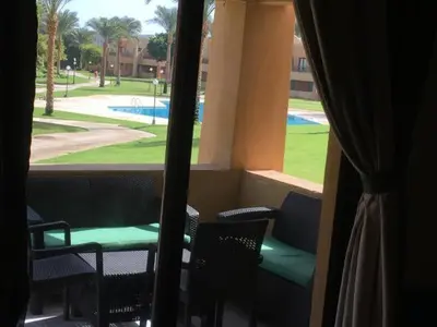 a room with a window with chairs and a pool at Apartment in Stella di Mare Hurghada in Hurghada