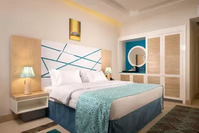 a bedroom with a large bed and a mirror at Gravity Hotel & Aqua Park Sahl Hasheesh Families and Couples Only in Hurghada