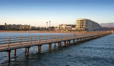 a bridge over the water next to a beach at Gravity Hotel & Aqua Park Sahl Hasheesh Families and Couples Only in Hurghada
