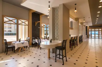 a dining room with tables and chairs and windows at Gravity Hotel & Aqua Park Sahl Hasheesh Families and Couples Only in Hurghada