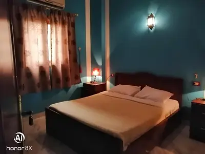 a bedroom with a bed and a blue wall at Al Hambra Hotel in Luxor