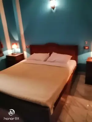 a bed with white sheets and pillows in a room at Al Hambra Hotel in Luxor