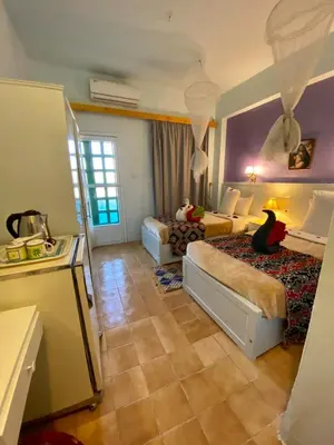 a hotel room with two beds and a kitchen at El Gezira Hotel in Luxor