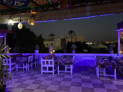 a table and chairs on a patio at night at El Gezira Hotel in Luxor