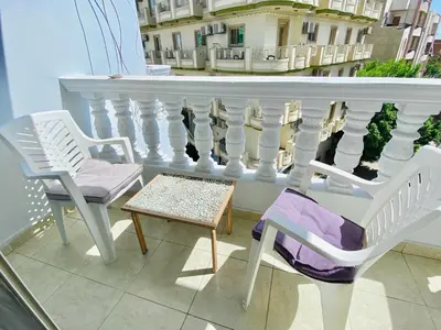 a balcony with two chairs and a table and a white railing at Elephant House with Sea View in Hurghada