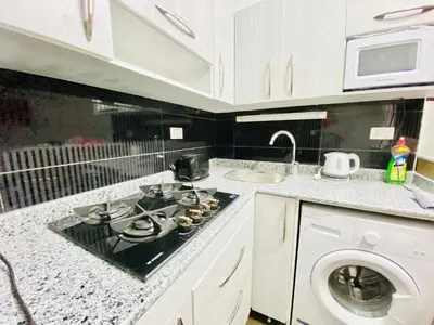 a kitchen with a stove top oven next to a washing machine at Zebra House Hurghada center in Hurghada