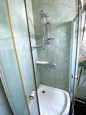 a shower with a glass door next to a toilet at Zebra House Hurghada center in Hurghada