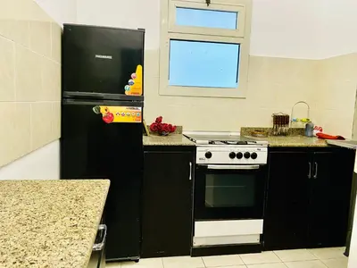 a kitchen with a stove and a black refrigerator at Jazz House Hurghada canter with WI FI in Hurghada