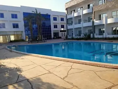 a large swimming pool in front of a building at Chalet in Cecelia Resort in Hurghada