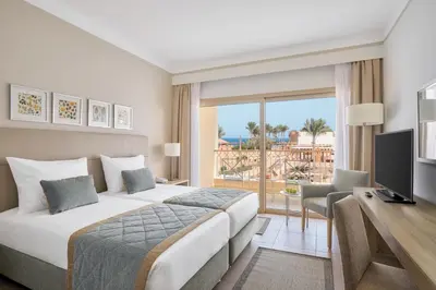 a bedroom with a bed and a desk and a television at JAZ Elite Maraya in Coraya Bay