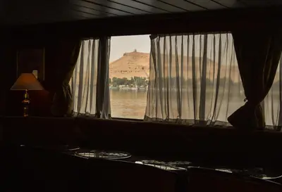 a room with a window with a view of the water at Nile Cruise Luxor Aswan 3,4 and 7 nights in Aswan