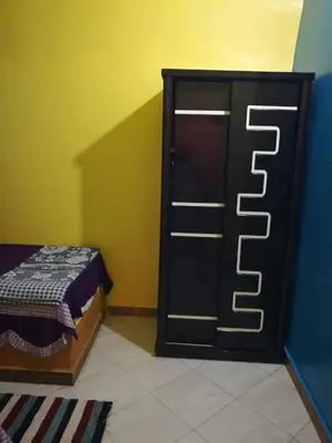 a bedroom with a bed and a black door at Kindaka amany in Aswan