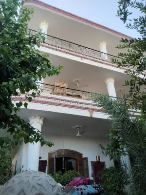 a large white building with a balcony at Villa Quiet Place in Luxor