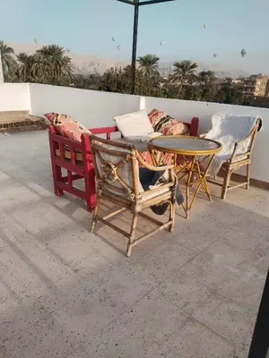 a patio with a table and chairs and a couch at Villa Quiet Place in Luxor
