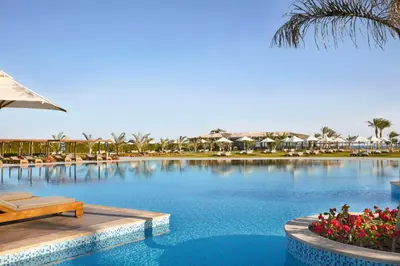 a pool at a resort with a table and chairs at Steigenberger Resort Alaya Marsa Alam - Red Sea - Adults Friendly 16 Years Plus in Coraya Bay