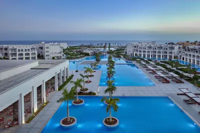 an aerial view of a hotel pool with palm trees and buildings at Steigenberger Resort Alaya Marsa Alam - Red Sea - Adults Friendly 16 Years Plus in Coraya Bay