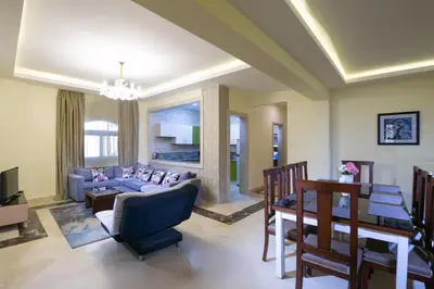 a living room with a blue couch and a table at Serenity Home Hurghada in Hurghada