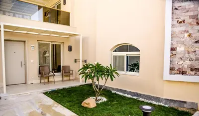 a house with a palm tree in the courtyard at Serenity Home Hurghada in Hurghada
