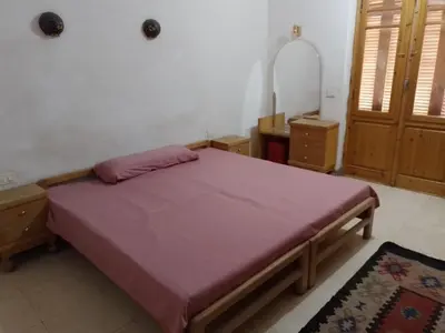 a bedroom with a large bed with a purple blanket at Adad Noubian House in Aswan