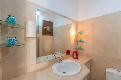 a bathroom with a sink and a mirror and a toilet at El gouna South Marina Townhouse Apartment 3 bedrooms in Hurghada