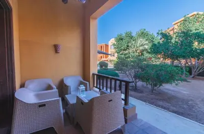 a balcony with chairs and a table and a window at El gouna South Marina Townhouse Apartment 3 bedrooms in Hurghada