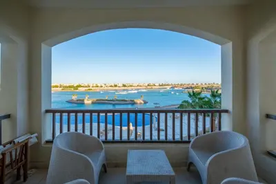 a balcony with chairs and a view of the water at Luxury 3 Bedroom Apt. in El Gouna with amazing view in Hurghada