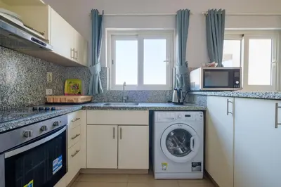 a kitchen with a washing machine and a microwave at Luxury 3 Bedroom Apt. in El Gouna with amazing view in Hurghada