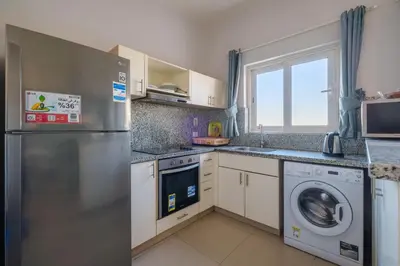 a kitchen with a refrigerator and a washing machine at Luxury 3 Bedroom Apt. in El Gouna with amazing view in Hurghada