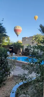 a hot air balloon flying over a swimming pool at Villa Bahri Luxor Apartment in Luxor